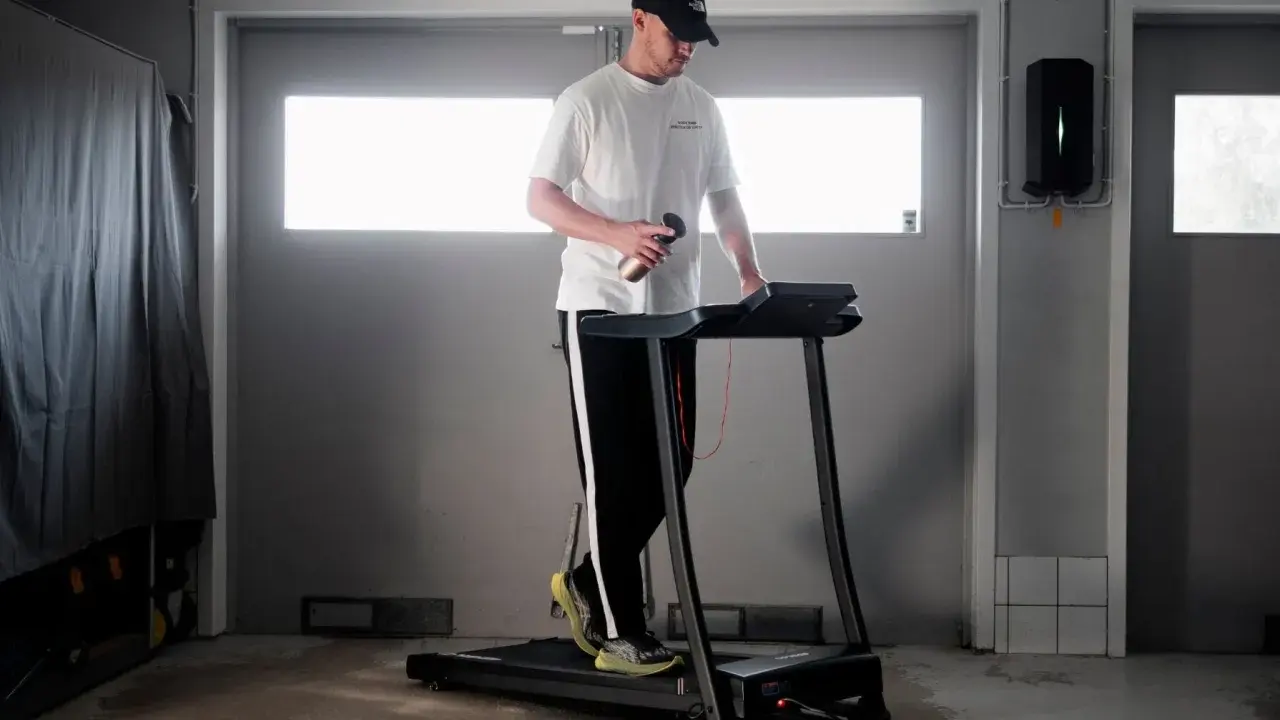 Man med keps tränar på löpband, siktar på att springa 5 km på 30 min.
