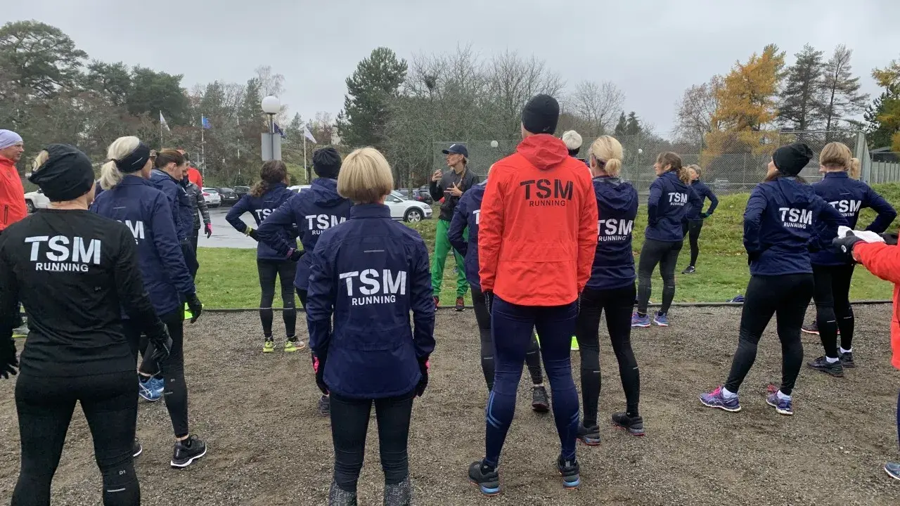Ett team från TSM Running samlas utomhus, redo för träning.