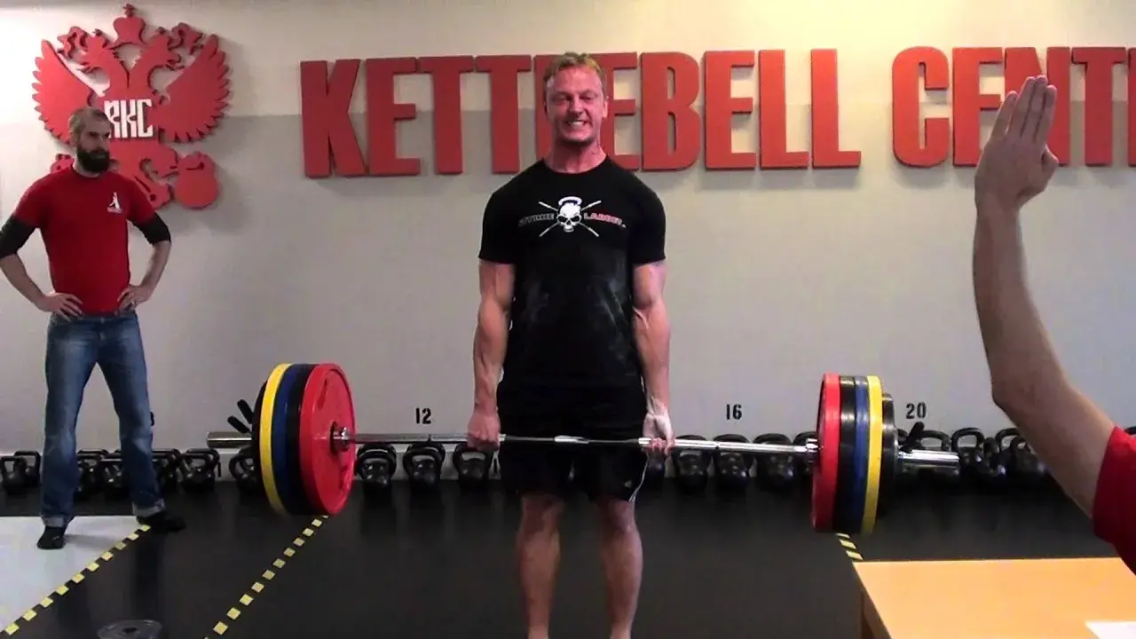Man i gymmet gör sig redo för ett tungt intervall pass med skivstång.