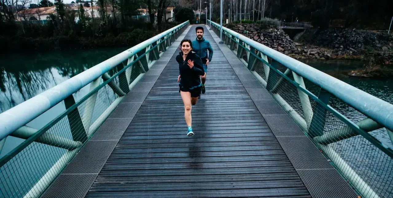 Ett par springer över en bro, redo för sitt 10 km lopp.