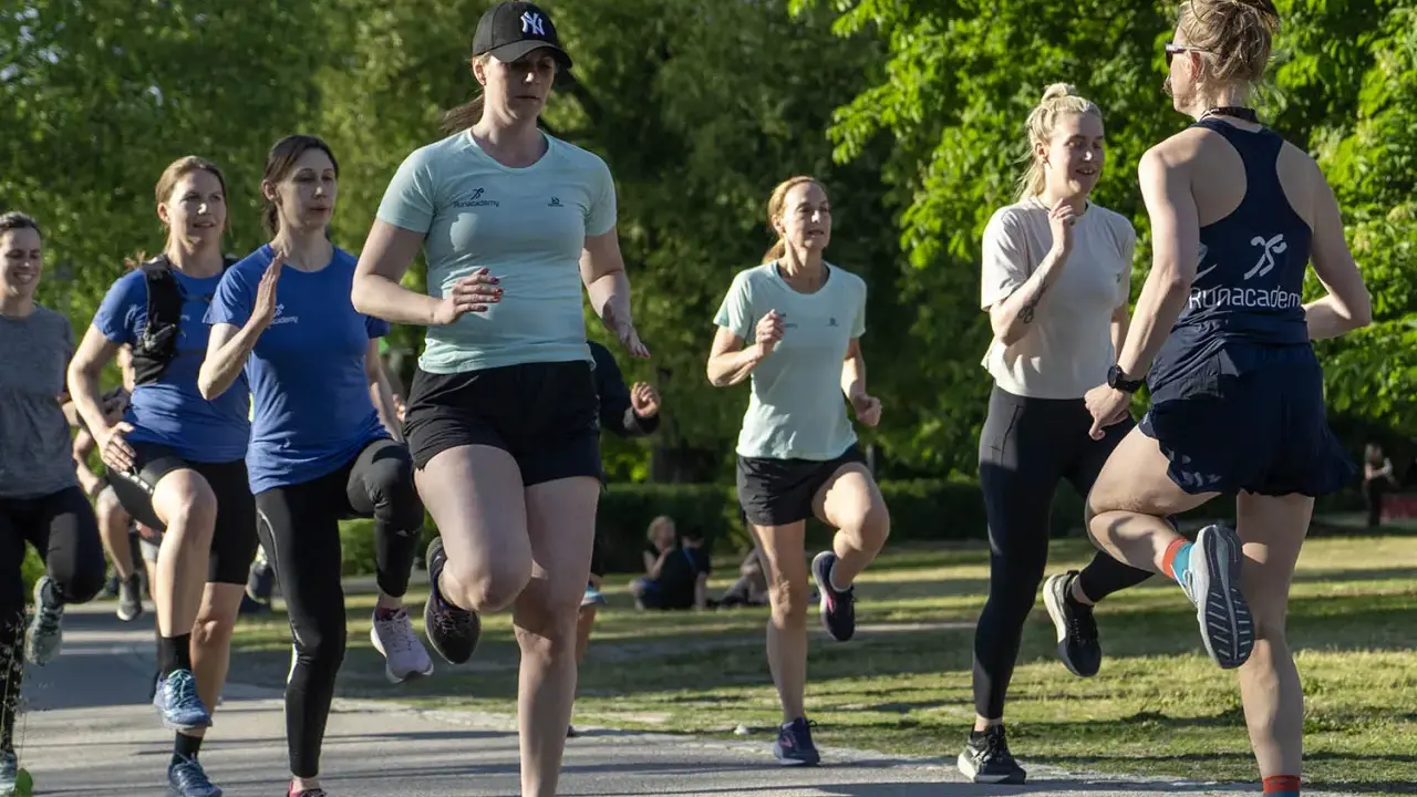 En grupp kvinnor tränar löpning i en park, redo att springa 3 km.
