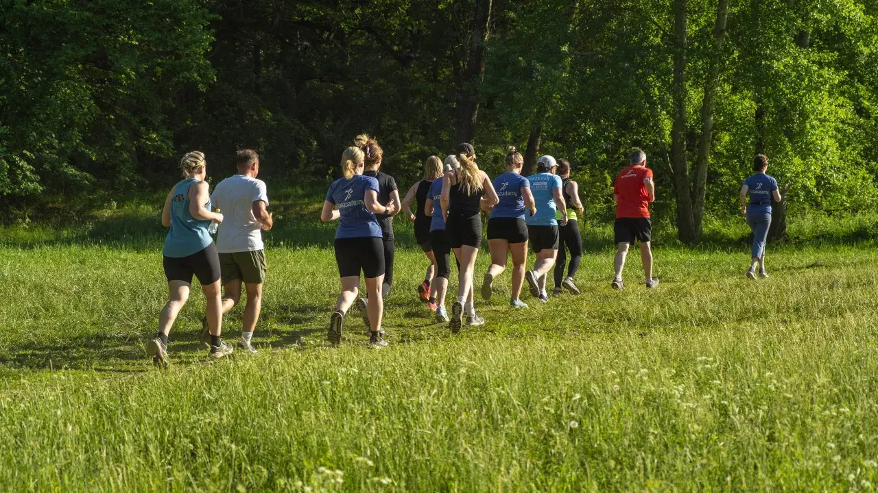 En grupp löpare njuter av roliga intervaller i en grönskande park.