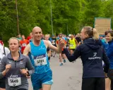 Glada löpare hejar på varandra under sista veckan innan halvmarathon. En man ger en high five till en kvinna.
