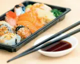 En låda med sushi och sashimi, redo att ätas. Perfekt för den som vill **springa efter mat** utan att kompromissa med smaken.