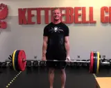 Man i gymmet gör sig redo för ett tungt intervall pass med skivstång.