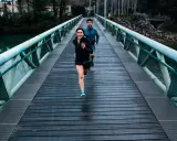 Ett par springer över en bro, redo för sitt 10 km lopp.