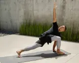 Man i yoga-ställning, med en arm sträckt uppåt. Han springer fort i sin träning.