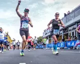Glada löpare i BMW Berlin Marathon. Petra, med nummer 24287, firar sin framgång. En härlig dag för runners world triathlon.