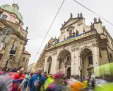 Löpare i Prag halvmarathon passerar en byggnad med en banderoll "HANDS OFF UKRAINE, PUTIN!".