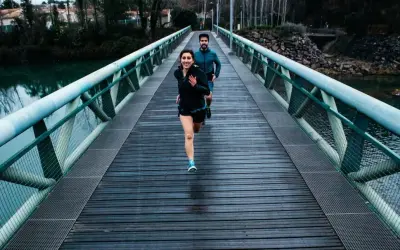 Ett par springer över en bro, redo för sitt 10 km lopp.