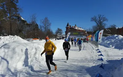 Löpare i snöig terräng, på väg mot en finishlinje. Kanske ett backyard ultra rekord sätts idag!