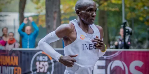 Eliud Kipchoge springer mot sitt mål, det snabbaste maraton någonsin. Publiken hejar på i bakgrunden.