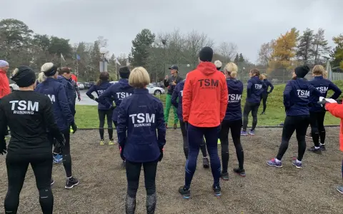 Ett team från TSM Running samlas utomhus, redo för träning.