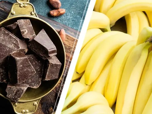 Dark chocolate chunks in a bowl and a pile of ripe bananas.