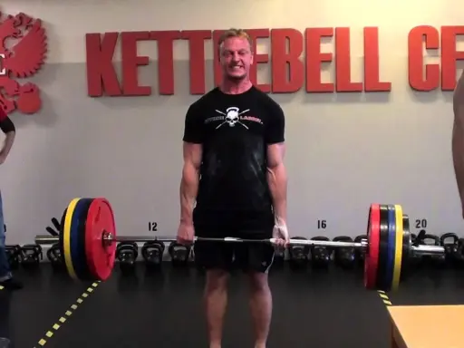 Man i gymmet gör sig redo för ett tungt intervall pass med skivstång.