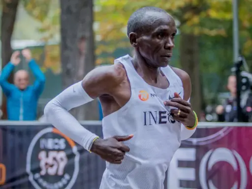 Eliud Kipchoge springer mot sitt mål, det snabbaste maraton någonsin. Publiken hejar på i bakgrunden.