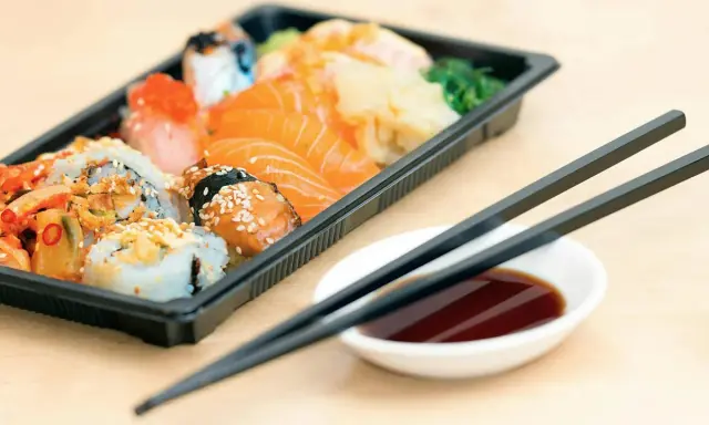 En låda med sushi och sashimi, redo att ätas. Perfekt för den som vill **springa efter mat** utan att kompromissa med smaken.