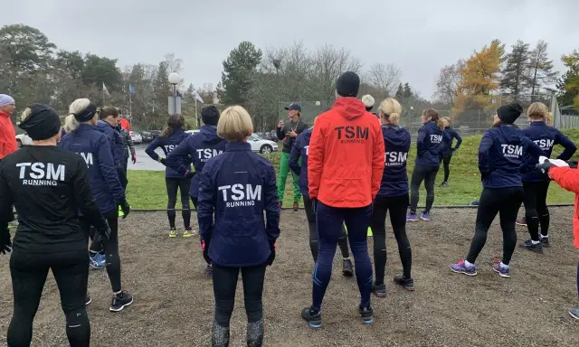 Ett team från TSM Running samlas utomhus, redo för träning.