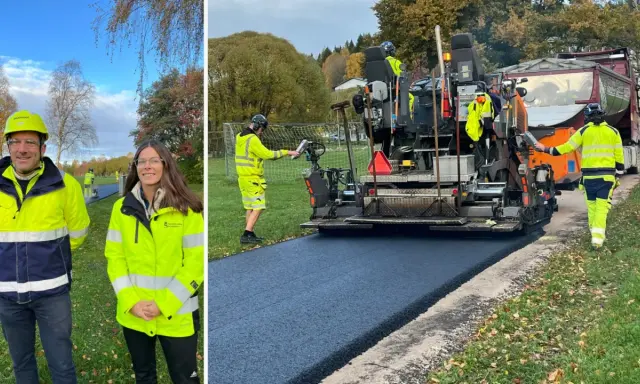 Två personer i varselkläder står framför en asfaltsläggare som lägger nytt asfalt.