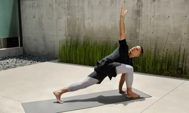 Man i yoga-ställning, med en arm sträckt uppåt. Han springer fort i sin träning.