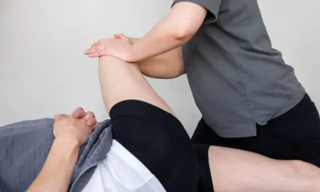 Fysioterapeut behandlar en patient med misstänkt muskelbristning i rumpan.