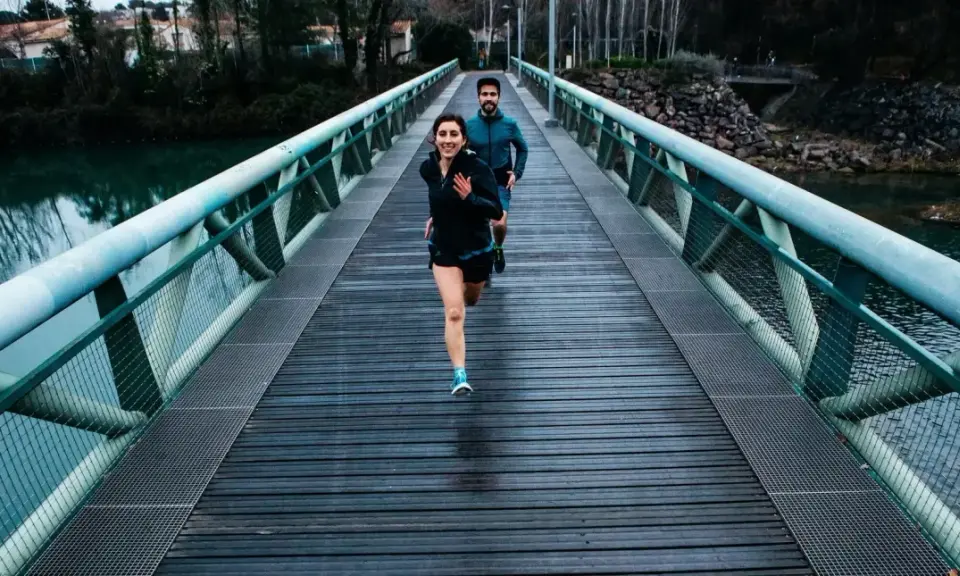 Ett par springer över en bro, redo för sitt 10 km lopp.
