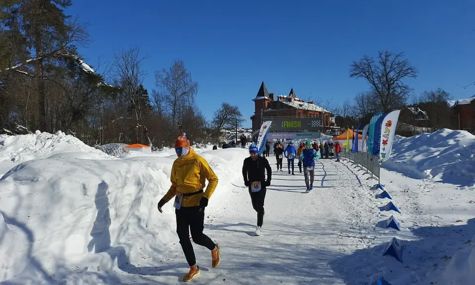 Löpare i snöig terräng, på väg mot en finishlinje. Kanske ett backyard ultra rekord sätts idag!