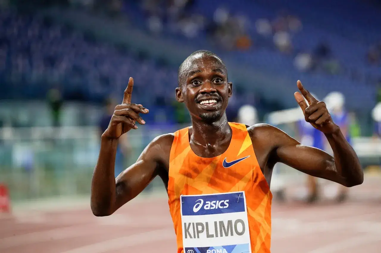 Jacob Kiplimo firar sitt nya rekord halvmaraton med ett leende och fingrarna upp&aring;t.