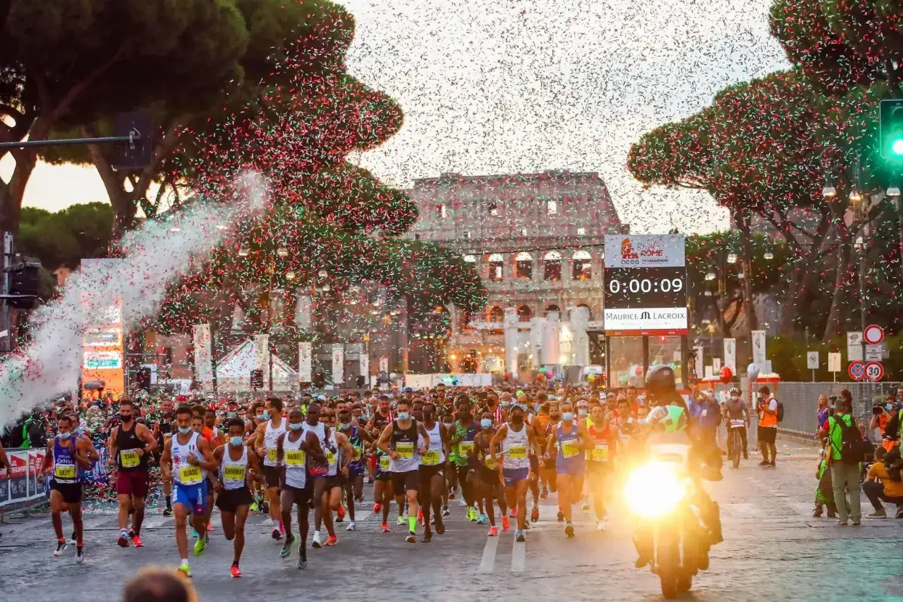 L&ouml;pare springer i en rom marathon under konfetti. Colosseum syns i bakgrunden.