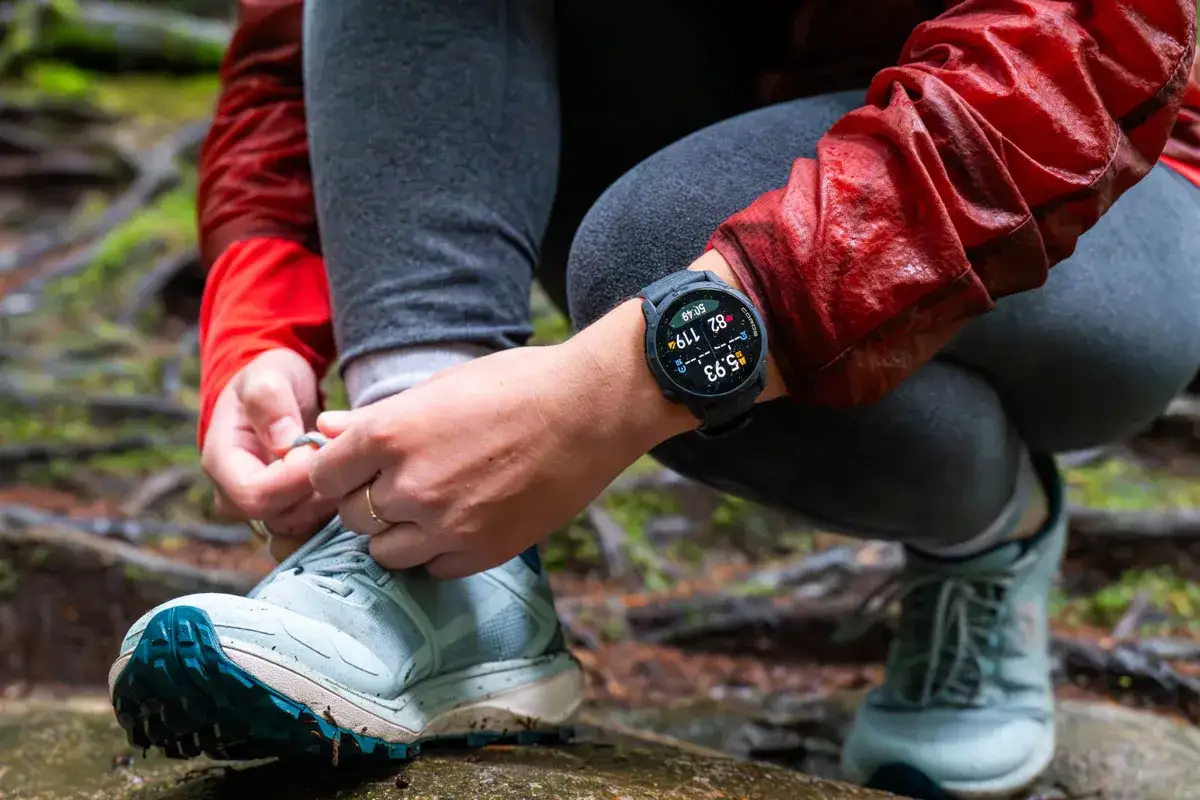 Person knyter skosn&ouml;ren, redo f&ouml;r en l&ouml;prunda. Klockan visar 5.93 km, redo f&ouml;r n&auml;sta mil.