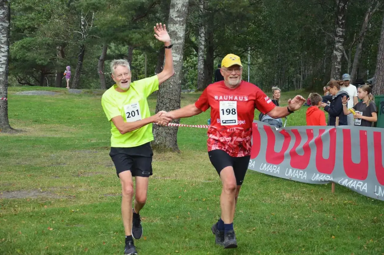 Tv&aring; glada l&ouml;pare, nummer 201 och 198, skakar hand vid k&aring;sj&ouml;n trail.