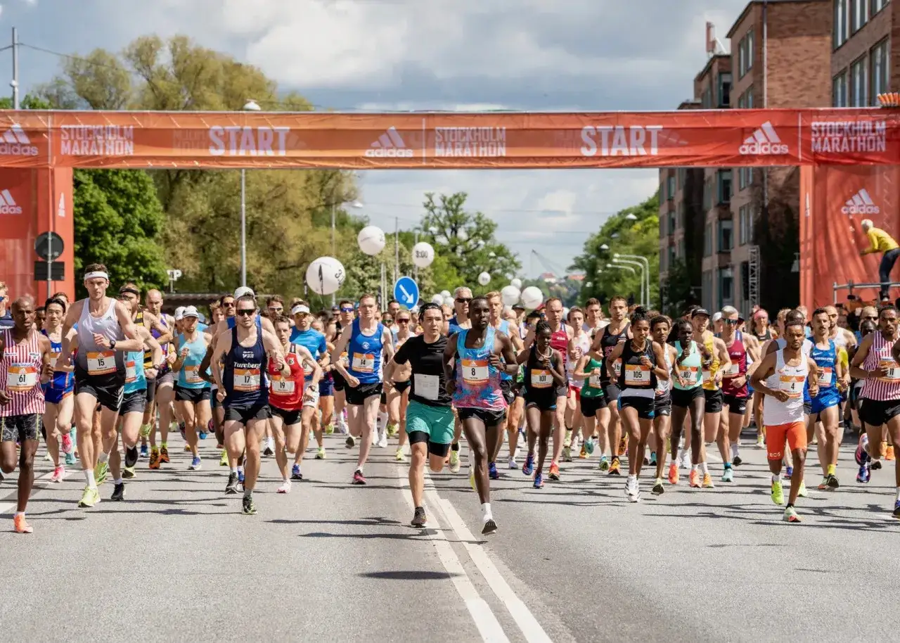 L&ouml;pare springer under en orange startportal vid Stockholm Marathon.