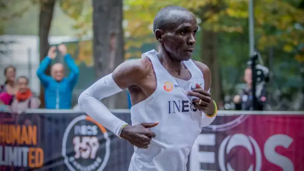 Eliud Kipchoge springer mot sitt mål, det snabbaste maraton någonsin. Publiken hejar på i bakgrunden.