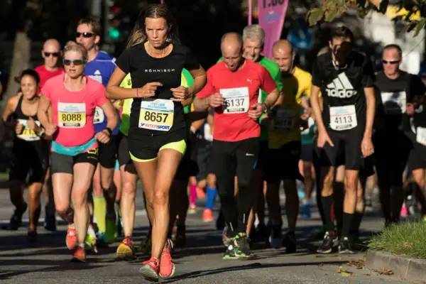 Löpare i Stockholm Halvmarathon kämpar för ett rekord. En kvinna med nummer 8657 leder loppet.