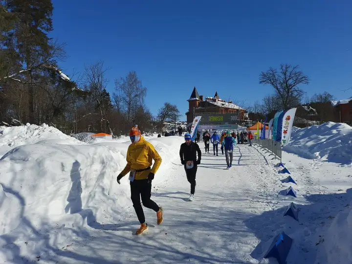 Löpare i snöig terräng, på väg mot en finishlinje. Kanske ett backyard ultra rekord sätts idag!