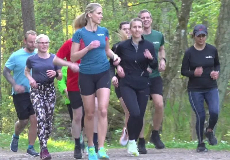 En grupp löpare njuter av en löprunda i skogen, en härlig lopp i Stockholm.